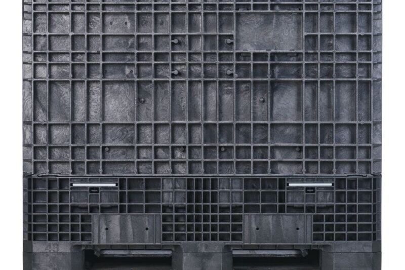 GP4048-39_LS_BLACK The GP4048-39 is a large black plastic industrial pallet featuring a grid-like structure, visible slats, and forklift openings, shown from the side.