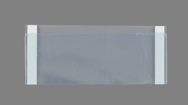 A transparent adhesive document holder, identified as DC3120-XL, features white adhesive strips on both sides, set against a gray background.