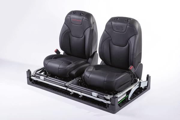 Two black automotive seats are mounted on plastic pallet.